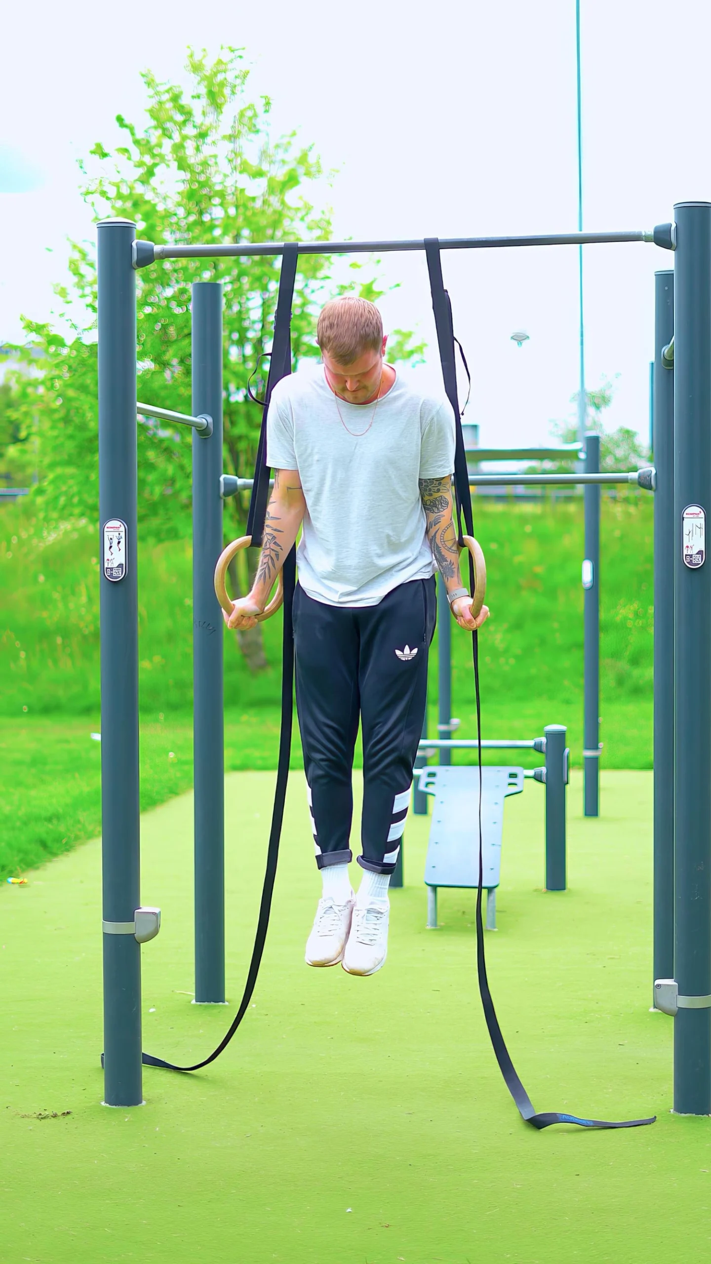 Client doing a ring dip on rings outdoors in Glasgow